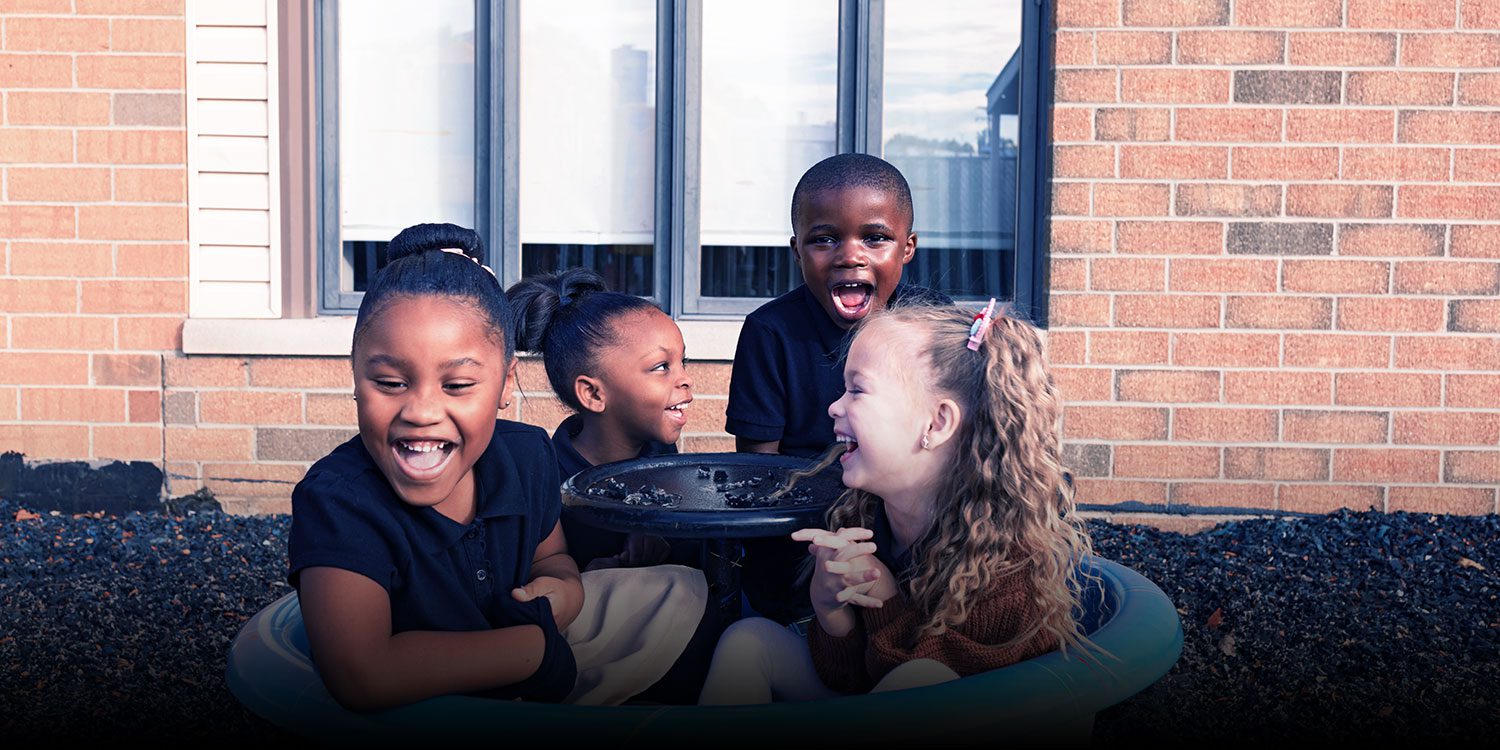 A group of happy students sitting in a circle at the playground